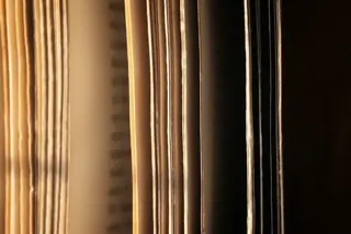 Edges of stacked paper documents lit from one side